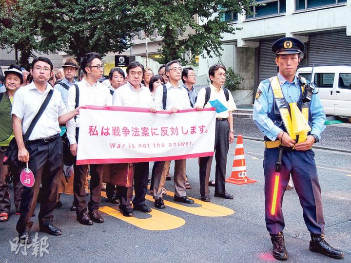 參加反安保法案遊行的市民，在砂防會館外靜待警方指示，等候出發。（林康琪攝）