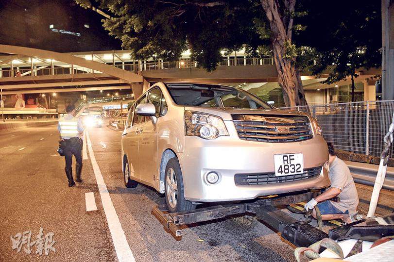 中區昨凌晨發生馬路中換胎捱撞車禍,事後爆胎的七人車由拖車拖走。(蔡方山攝) 中區昨凌晨發生馬路中換胎捱撞車禍,事後爆胎的七人車由拖車拖走。(蔡方山攝)