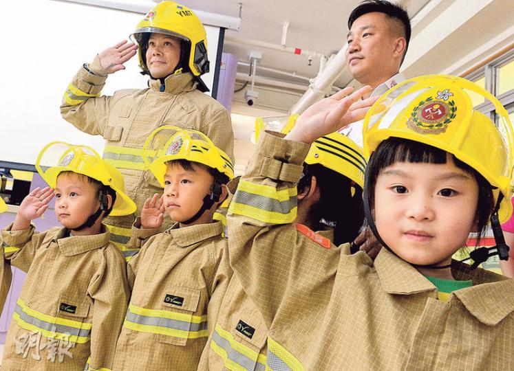 消防處幼兒消防安全教育計劃在2011年11月推出,旨在培養學前兒童正確消防安全觀念。上周三,計劃其中兩名導師馮敬祥(後排左起)和李紹輝到石圍角邨一幼稚園向幼兒講解消防安全信息,又安排10名孩子穿上消防處為教育計劃特別訂做的Q版消防制服。(劉焌陶攝) 消防處幼兒消防安全教育計劃在2011年11月推出,旨在培養學前兒童正確消防安全觀念。上周三,計劃其中兩名導師馮敬祥(後排左起)和李紹輝到石圍角邨一幼稚園向幼兒講解消防安全信息,又安排10名孩子穿上消防處為教育計劃特別訂做的Q版消防制服。(劉焌陶攝)