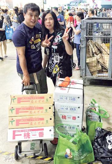 住喺馬鞍山嘅程先生(左)同李小姐(右),喺美食博覽花咗約3000蚊買咗9箱桃,佢哋覺得今年博覽貨品嘅價錢同街外差不多。(程梓龍攝) 住喺馬鞍山嘅程先生(左)同李小姐(右),喺美食博覽花咗約3000蚊買咗9箱桃,佢哋覺得今年博覽貨品嘅價錢同街外差不多。(程梓龍攝)