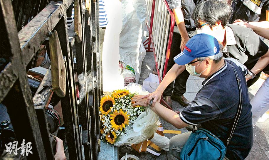 19歲死者陳詠釿的父親(前)帶着一束太陽花到場,其間撫摸花束,低語「快啲返嚟呀,傻豬仔」,淚如泉湧的他由妻子(後)安慰。(林俊源攝) 19歲死者陳詠釿的父親(前)帶着一束太陽花到場,其間撫摸花束,低語「快啲返嚟呀,傻豬仔」,淚如泉湧的他由妻子(後)安慰。(林俊源攝)