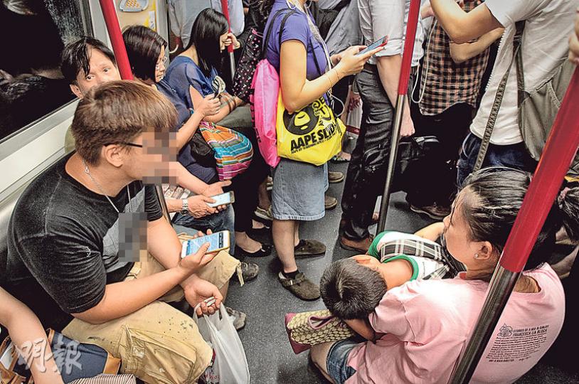 本報記者今日傍晚乘港鐵時，看到一名女士手抱小孩，倚着扶手柱半蹲在地，無人讓座。記者用相機攝下情况後，坐在該女士附近的一名年輕男子高聲質問記者為何拍照，有市民回應﹕「你咁後生，見人哋抱住BB都唔讓座，咪要影你囉！」記者不為所動，該男子繼續大聲質問記者﹕「佢抱住細路我唔讓，你就要影我？」該男子罵完記者，繼續坐在座位上使用手機，直到記者下車，也不見有人讓座予該手抱小孩的女士。（李澤彤攝）