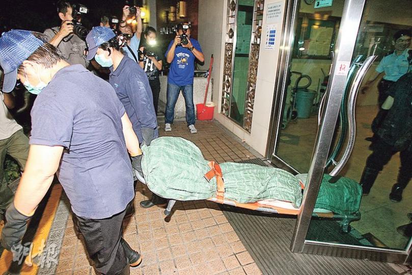 起火單位戶主的兒子被發現倒斃天台機房旁,屍體由仵工舁送殮房。(伍浦鋒攝) 起火單位戶主的兒子被發現倒斃天台機房旁,屍體由仵工舁送殮房。(伍浦鋒攝)