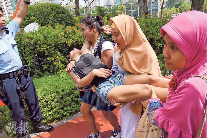 一名印尼人疑似中暑昏迷,由友人合力抬起移往陰涼地方,沿途更大叫「幫手呀、幫手呀」。(林智傑攝) 一名印尼人疑似中暑昏迷,由友人合力抬起移往陰涼地方,沿途更大叫「幫手呀、幫手呀」。(林智傑攝)