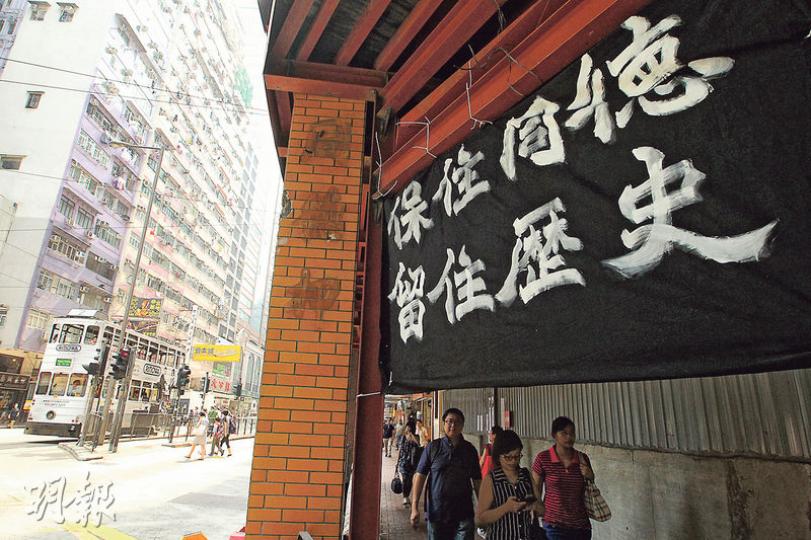 有地區組織成員在古諮會會議結束後，到灣仔同德押掛上寫有「保住同德 留住歷史」的黑色橫額，要求政府將同德押改列為暫定古蹟，叫停清拆。（林俊源攝）古諮會昨召開特別會議，3名委員在會上舉手支持將同德押提升至二級歷史建築，但由於人數不足一半而遭否決，最終古諮會維持同德押的三級歷史評級。（鍾林枝攝）
