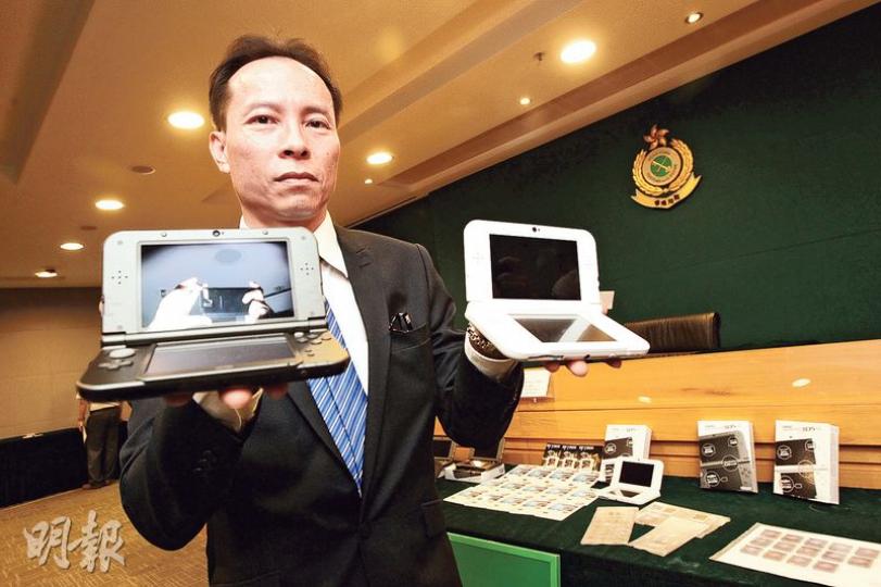 海關版權及商標科技罪案調查組指揮官方永佳在記者會上,分別講述破案經過及展示檢獲的電子遊戲產品。(李紹昌攝)涉案店舖是在網上下載正版遊戲的破解版儲入記憶卡(左圖黑色卡)後,再插入規避器(左圖白色卡),然後將規避器插入手提電子遊戲機,令遊戲機系統誤認是正版遊戲。右圖為正版遊戲卡。(李紹昌攝) 海關版權及商標科技罪案調查組指揮官方永佳在記者會上,分別講述破案經過及展示檢獲的電子遊戲產品。(李紹昌攝)涉案店舖是在網上下載正版遊戲的破解版儲入記憶卡(左圖黑色卡)後,再插入規避器(左圖白色卡),然後將規避器插入手提電子遊戲機,令遊戲機系統誤認是正版遊戲。右圖為正版遊戲卡。(李紹昌攝)
