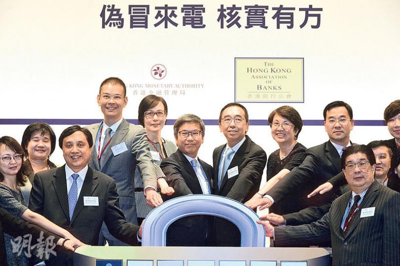 金管局、銀行公會等合作,提高市民對偽冒銀行來電的防範意識,昨舉辦宣傳活動,金管局副總裁阮國恒(左四)認為,市民對防範電話騙案意識不足,冀21間銀行設立熱線後,有助核實聲稱銀行職員的來電者真偽。左五為銀行公會署理主席梁兆基。(蘇智鑫攝) 金管局、銀行公會等合作,提高市民對偽冒銀行來電的防範意識,昨舉辦宣傳活動,金管局副總裁阮國恒(左四)認為,市民對防範電話騙案意識不足,冀21間銀行設立熱線後,有助核實聲稱銀行職員的來電者真偽。左五為銀行公會署理主席梁兆基。(蘇智鑫攝)