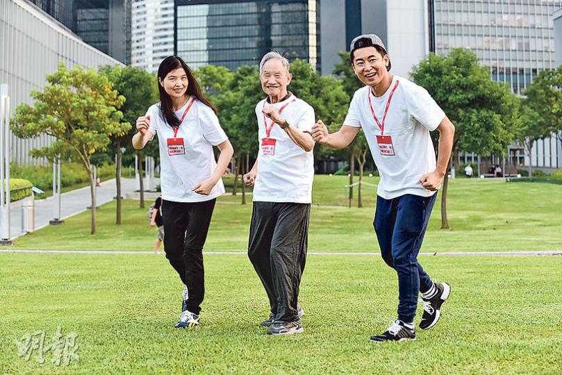 義工Ellis(右)與Funky(左)陪同88歲長者李文(中)一起到添馬公園練跑。李伯在安老院中不苟言笑,但到公園後即笑逐顏開。李伯說自己平日很少外出,但其實很喜歡活動,能出來練跑感到開心。 (陳淑安攝) 義工Ellis(右)與Funky(左)陪同88歲長者李文(中)一起到添馬公園練跑。李伯在安老院中不苟言笑,但到公園後即笑逐顏開。李伯說自己平日很少外出,但其實很喜歡活動,能出來練跑感到開心。 (陳淑安攝)