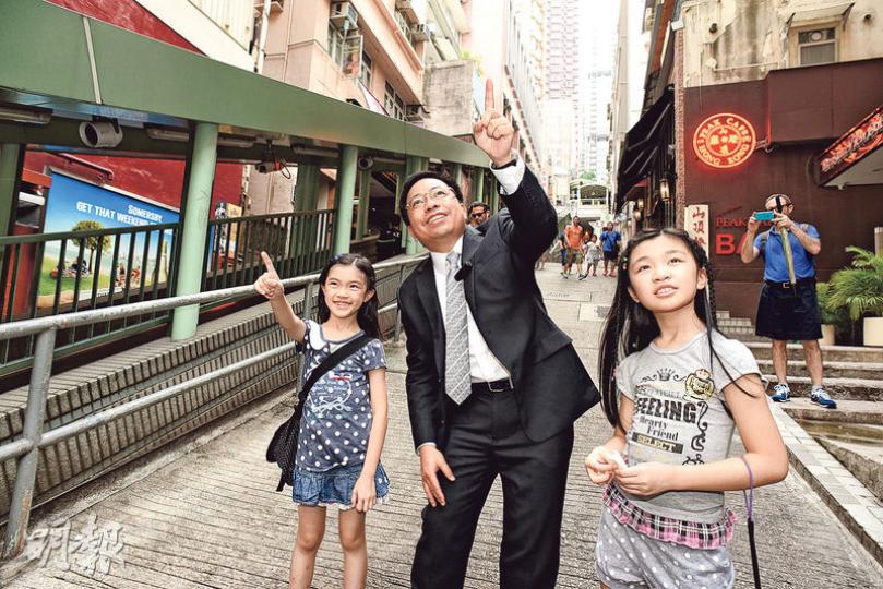 香港測量師學會會長何鉅業親自帶小朋友認識今日的中區面貌。(陳淑安攝)平日我們使用中區行人扶手電梯,只知道它很長很長,其實它是帶動中半山發展的重要建設,令中區SOHO應運而生。細心留意,我們乘搭電梯時,可看到位於樓宇一、二層各式商舖,原來電梯令它們更易被發現,也就增加了它們的商機!(陳淑安攝)不經不覺,我們花數分鐘便經行人天橋由上環走至中環。行人天橋可做到人車分流,也可連貫主要建築物,是城巿發展中不可或缺的。(陳淑安攝)測量師何鉅業指中區新舊樓宇交替,甚具特色,然而為何不能全部一起重建呢?原來要考 香港測量師學會會長何鉅業親自帶小朋友認識今日的中區面貌。(陳淑安攝)平日我們使用中區行人扶手電梯,只知道它很長很長,其實它是帶動中半山發展的重要建設,令中區SOHO應運而生。細心留意,我們乘搭電梯時,可看到位於樓宇一、二層各式商舖,原來電梯令它們更易被發現,也就增加了它們的商機!(陳淑安攝)不經不覺,我們花數分鐘便經行人天橋由上環走至中環。行人天橋可做到人車分流,也可連貫主要建築物,是城巿發展中不可或缺的。(陳淑安攝)測量師何鉅業指中區新舊樓宇交替,甚具特色,然而為何不能全部一起重建呢?原來要考