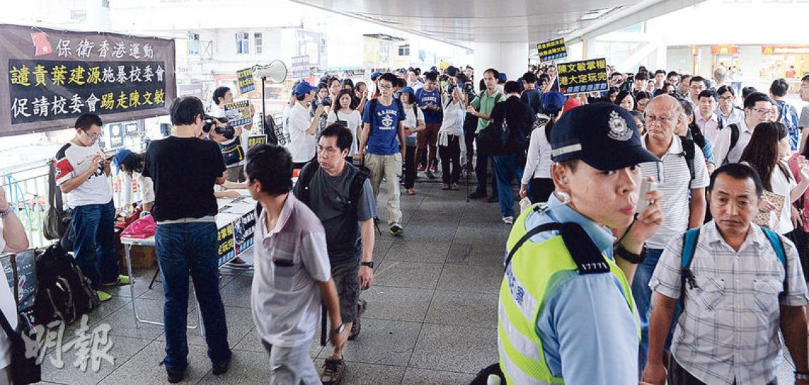 逾50名「保衛香港運動」成員昨在會議前在港鐵站通往會展的天橋擺街站，指港大法律學院前院長陳文敏掌權會令港大「玩完」等，其間有警員維持秩序。（劉焌陶攝）