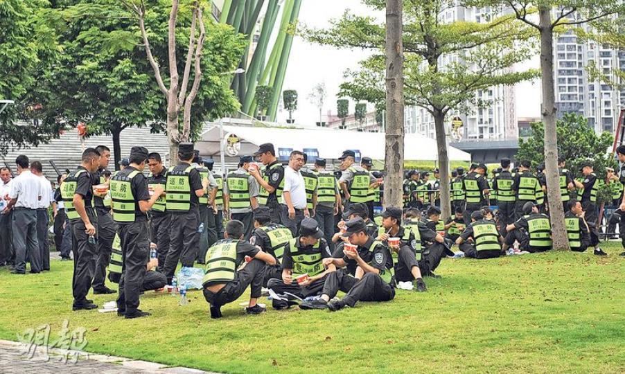 為香港球迷的南入口昨日早有大量公安、守衛及武警跑進(上圖),相比東門於綠油油草上開餐醫肚的守衛們(下圖),氣氛卻天壤之別。(楊宇翹攝) 為香港球迷的南入口昨日早有大量公安、守衛及武警跑進(上圖),相比東門於綠油油草上開餐醫肚的守衛們(下圖),氣氛卻天壤之別。(楊宇翹攝)