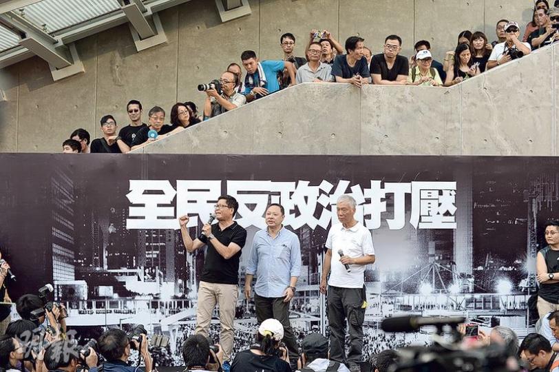 民陣與多個民間團體昨在「連儂牆」前舉行佔領運動一周年集會,大台由昔日的「命運自主」變成「全民反政治打壓」。集會由佔中三子陳健民(左起)、戴耀廷和朱耀明打頭陣。陳說爭取民主需要幾十年光景,籲市民不要因挫折感灰心。(鍾林枝攝) 民陣與多個民間團體昨在「連儂牆」前舉行佔領運動一周年集會,大台由昔日的「命運自主」變成「全民反政治打壓」。集會由佔中三子陳健民(左起)、戴耀廷和朱耀明打頭陣。陳說爭取民主需要幾十年光景,籲市民不要因挫折感灰心。(鍾林枝攝)