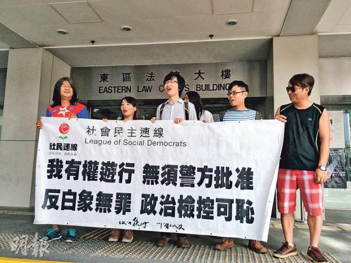 社民連成員包括案中被告黃永志(左三)在庭外展示「無須警方批准 反白象無罪」橫額,社民連主席梁國雄(左一)亦到庭聲援。(植敏欣攝) 社民連成員包括案中被告黃永志(左三)在庭外展示「無須警方批准 反白象無罪」橫額,社民連主席梁國雄(左一)亦到庭聲援。(植敏欣攝)