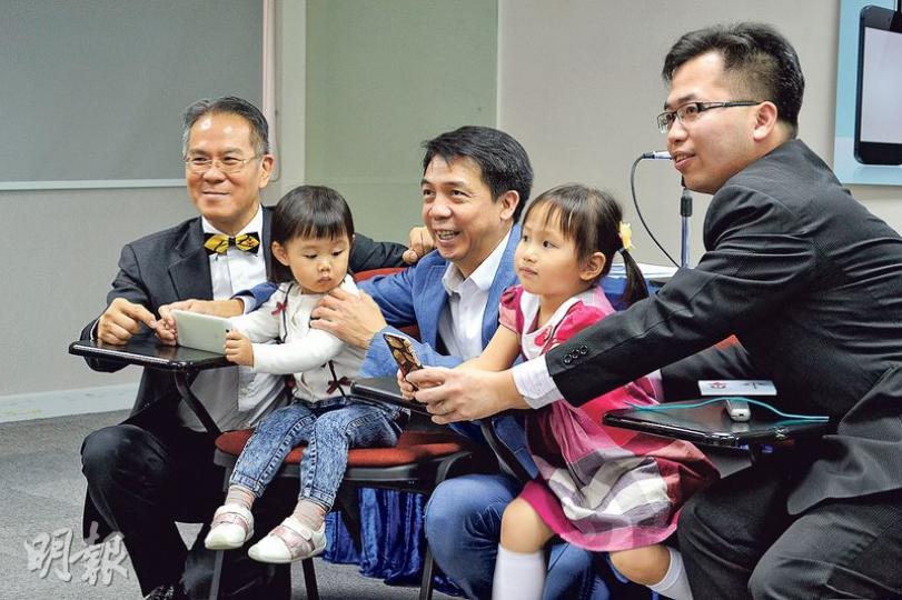香港眼科醫學院院長周伯展(左一)與幼童示範使用智能電話時,應保持30厘米距離。圖左三為中大眼科及視覺科學學系助理教授任卓昇,右一為香港眼科醫學院會董高德全。(黃文雋攝) 香港眼科醫學院院長周伯展(左一)與幼童示範使用智能電話時,應保持30厘米距離。圖左三為中大眼科及視覺科學學系助理教授任卓昇,右一為香港眼科醫學院會董高德全。(黃文雋攝)
