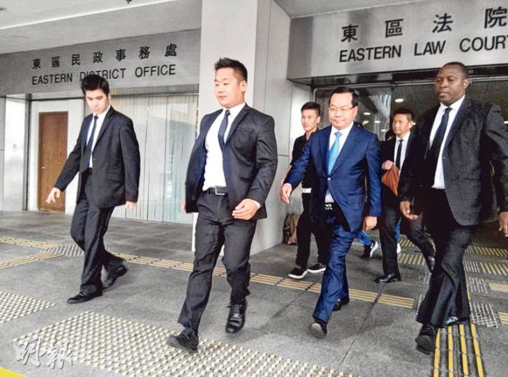 許智明(前排右二)在保鑣等共逾20人護送下離開,有人阻擋記者拍照。許一方稱,許回港後已立即現身警署處理本案,強調不會缺席聆訊。(何偉畧攝) 許智明(前排右二)在保鑣等共逾20人護送下離開,有人阻擋記者拍照。許一方稱,許回港後已立即現身警署處理本案,強調不會缺席聆訊。(何偉畧攝)