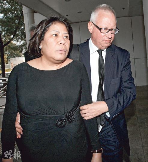 男女被告雖非法定夫妻，但每次到庭均十指緊扣。他們昨到庭時，男被告（右）見多傳媒訪攝，輕扶女被告（左）的腰及緊握其手臂，以防她受碰撞。兩人最終未能手挽手離開法院。（李紹昌攝）