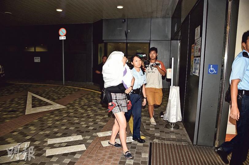 帶着3歲兒子離家揚言跳海尋死的婦人，由警員趕至碼頭尋獲，母子（白布蒙頭者）同送院檢驗。（蔡方山攝）