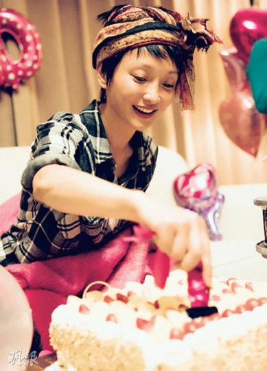 頭紮絲巾的周迅開心切蛋糕，慶祝41歲生日。（微博圖片）