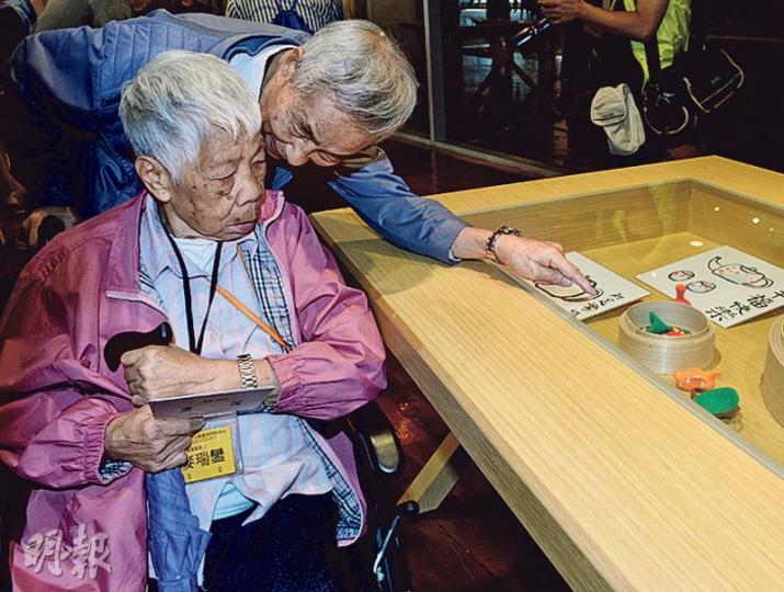九旬嘅鍾伯伯(右)推住患有腦退化症嘅太太出席展覽,其間細心向佢介紹展品。(劉焌陶攝) 九旬嘅鍾伯伯(右)推住患有腦退化症嘅太太出席展覽,其間細心向佢介紹展品。(劉焌陶攝)