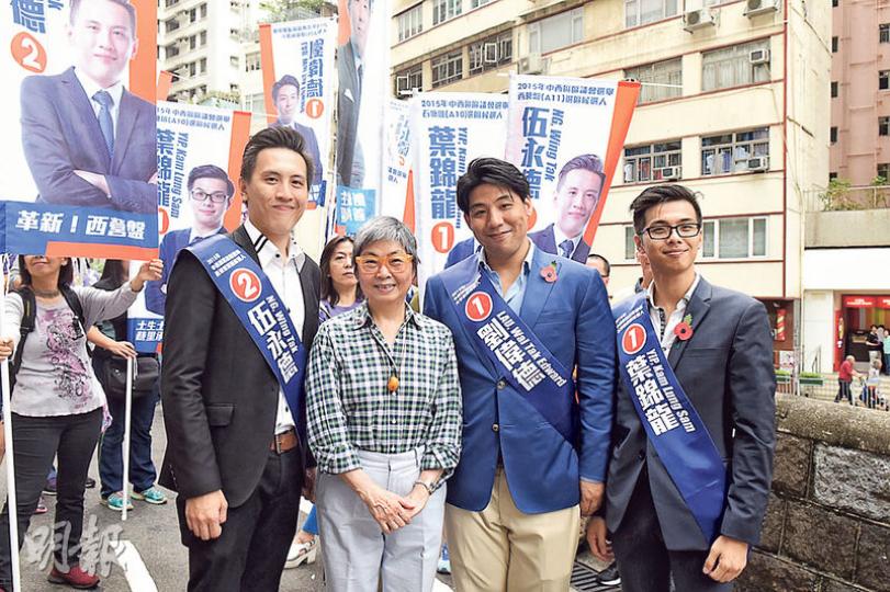 出選大學選區嘅劉偉德(右二)噚日喺般咸道石牆樹附近行人路搞競選集會,到場支持嘅吳靄儀(左二)話,希望選出嚟嘅人唔會「盲目斬樹」。(陳淑安攝)民建聯為新參選同「接棒」候選人舉行造勢會,葉國謙(左)喺觀龍選區交棒畀楊開永(右),話對楊開永有「101%信心」。(陳淑安攝) 出選大學選區嘅劉偉德(右二)噚日喺般咸道石牆樹附近行人路搞競選集會,到場支持嘅吳靄儀(左二)話,希望選出嚟嘅人唔會「盲目斬樹」。(陳淑安攝)民建聯為新參選同「接棒」候選人舉行造勢會,葉國謙(左)喺觀龍選區交棒畀楊開永(右),話對楊開永有「101%信心」。(陳淑安攝)