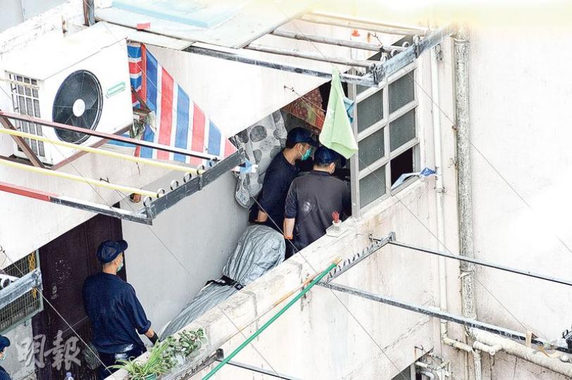 倒斃大廈梯間的六旬漢，屍體由仵工舁送殮房，死因有待剖驗。（賴俊傑攝）發生離奇命案的荃灣沙嘴道廣發大廈，警方調查期間要出入居民登記資料。（賴俊傑攝）