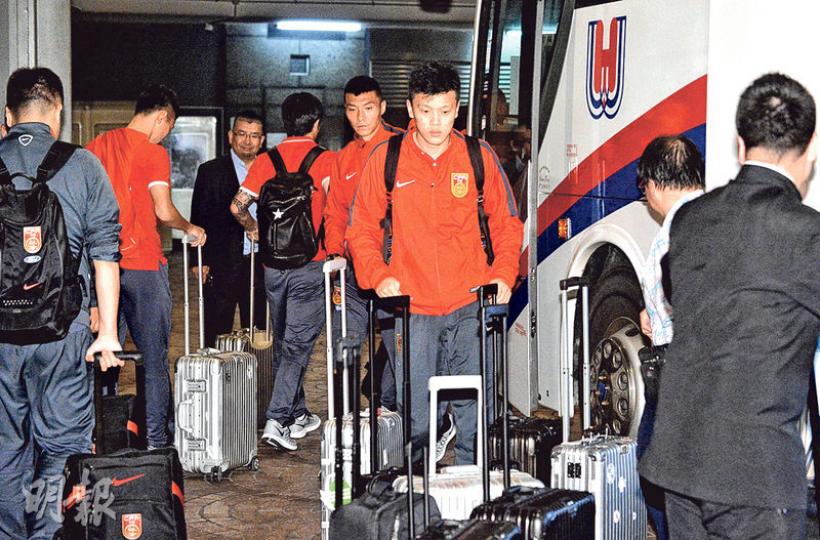 中國隊昨晚抵埗，經機場秘密通道直入停車場，乘旅遊巴往下榻的紅磡海逸君綽酒店。圖為國足中場鄒正（前）下車搬行李。（馮凱鍵攝）警方將於明晚9時35分球場結束前在旺角園藝街及園圃街封路，直至人潮散去。左為旺角警區助理指揮官（行政）余偉傑，右為旺角警區總督察（行動）孟天予。（葉真真攝）