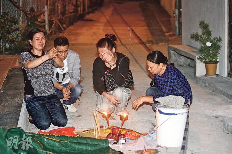 死者鄧姓前妻（左一）及其他親友，昨晚帶同祭品到死者倒卧位置拜祭，鄧一度嚎啕大哭，親友一臉愁容。（伍浦鋒攝）警方指死者遭同住的疑兇用1呎長菜刀揮斬，刺傷喉部及兩邊腋下。昨晚警員帶走3把刀化驗，圖為其中一把。（衛永康攝）