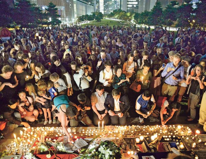 法國駐港澳總領事館昨傍晚在金鐘添馬公園舉行燭光集會，悼念巴黎恐怖襲擊中的死難者，有不少人出席，許多人帶來鮮花致意。（蘇智鑫攝）特首梁振英（右二）昨午到法國駐港澳總領事館簽弔唁冊後，晚上到添馬公園出席燭光晚會，向巴黎恐襲死難者致哀。（蘇智鑫攝）