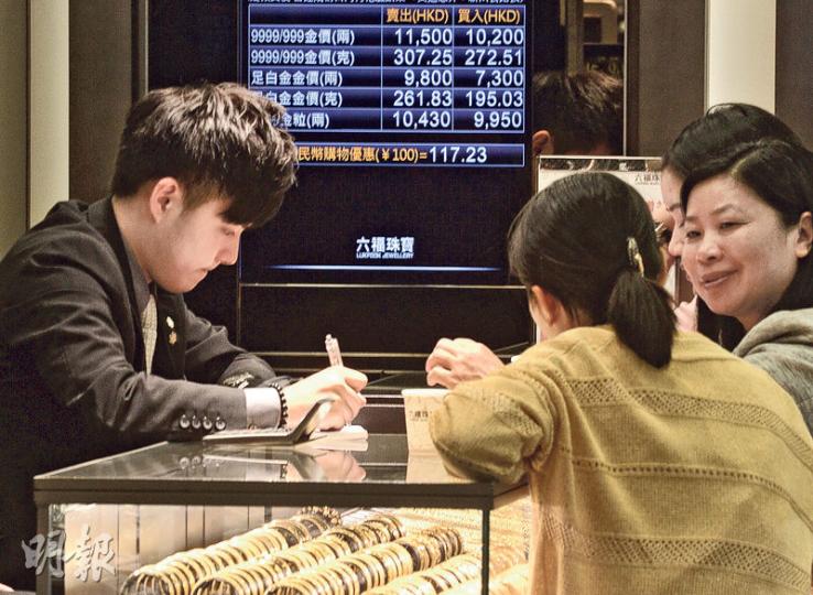 《競爭條例》昨生效，金飾業商會繼續公布建議飾金牌價。記者昨發現連鎖及小型金行的飾金價仍看齊商會價，飾金賣出價及買入價分別為11,500元及10,200元。（鍾林枝攝）