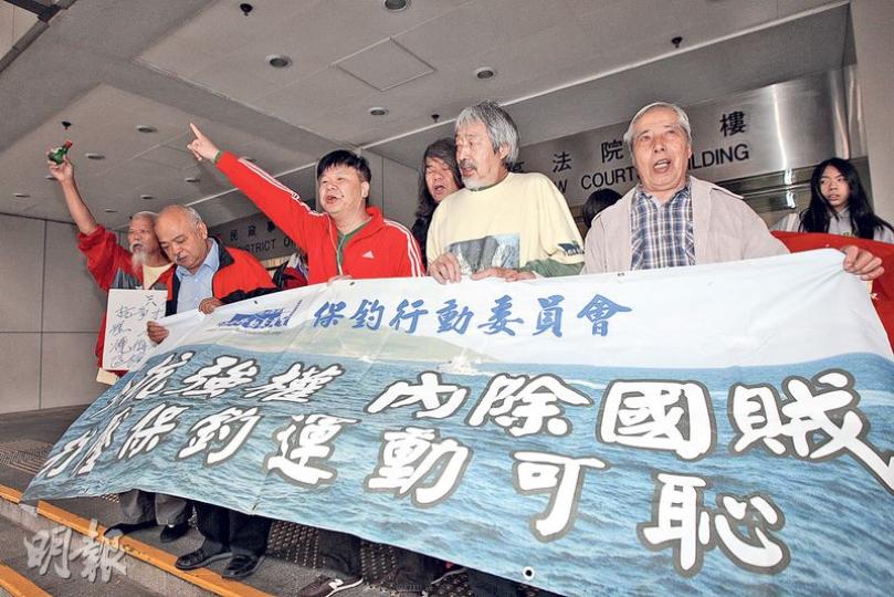 古思堯（左一）等在庭外舉起「只有抗爭才是硬道理，我故意焚燒侮辱國旗區旗」的標語，他又飲酒預祝自己將第5次入獄。（李紹昌攝）