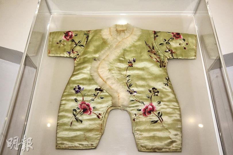 圖中的童服因狀似青蛙,俗稱「田雞褲」,為20世紀20年代的時尚,給剛出生的嬰兒穿著。前襟的邊飾以兔毛為材料,淡綠素緞上繡有「鳥語花香」及「花開富貴」的圖案。(郭慶輝攝)本港鶴佬的小童會在節日佩戴色彩鮮艷的口水肩。圖中的口水肩以棉布縫製而成,綴以金屬圓片及膠珠,色彩斑斕。(郭慶輝攝) 圖中的童服因狀似青蛙,俗稱「田雞褲」,為20世紀20年代的時尚,給剛出生的嬰兒穿著。前襟的邊飾以兔毛為材料,淡綠素緞上繡有「鳥語花香」及「花開富貴」的圖案。(郭慶輝攝)本港鶴佬的小童會在節日佩戴色彩鮮艷的口水肩。圖中的口水肩以棉布縫製而成,綴以金屬圓片及膠珠,色彩斑斕。(郭慶輝攝)