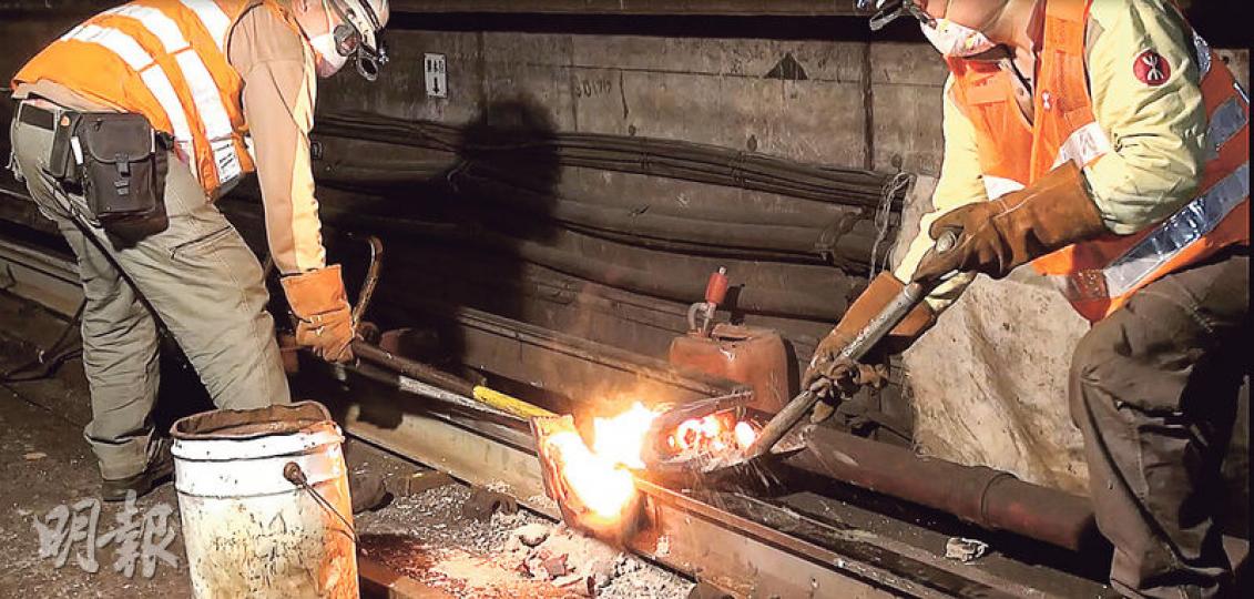 港鐵昨凌晨安排傳媒視察收車後檢查路軌和更換路軌的工作，工程人員先移除路軌旁的裝置如信號線，然後把須移除的路軌切割出來，並以「龍門架」把新路軌移至更換的位置，再以高熱熔掉鋁熱焊接物料及注入焊模中（圖），冷卻定形後打磨路軌形狀。（鄧力行攝）