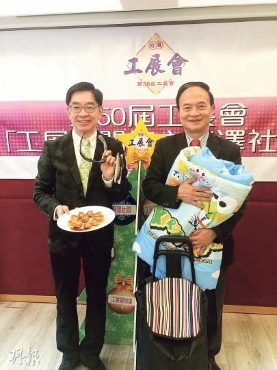 工展會1月3日首次邀請2000名獨居長者同殘疾人士免費入場，並贈送大禮包。廠商會會長李秀恒（左）同副會長戴澤良（右）向傳媒展示福袋物品，包括棉被、即食鮑魚、太陽眼鏡等。（渠贇攝）