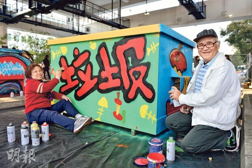 本港首個長者塗鴉工作坊學員吳國根（右）和太太羅錦英（左），在葵涌的貨櫃碼頭噴出第一件作品，這些被改頭換面的垃圾斗將放在碼頭各處供使用。（鄧宗弘攝）