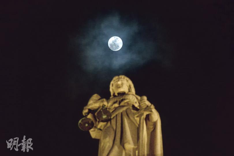昨夜的本世紀首個聖誕滿月遇上多雲的夜空，但雲層擋不住皎潔的明月，月光穿過雲隙照到香港的土地上，在終審法院上空現身。（鍾林枝攝）本港上空昨晚出現本世紀首個聖誕滿月，惜雲層偏厚，賞月市民不斷要在雲隙中與月亮「捉迷藏」，明月偶爾探出頭來，與閃爍燈飾爭妍。（楊柏賢攝）