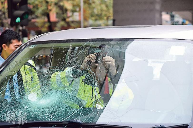 七人車在太子道西撞倒過馬路老翁，事後擋風玻璃龜裂，警員登車取走行車攝錄機的影片調查。（蔡方山攝）