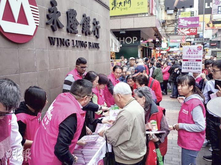 全港各區工商聯昨日在旺角派發月曆、粟米罐頭及優惠券等禮品，吸引逾百人排隊，更一度被商舖投訴阻礙生意。（王丹麟攝）