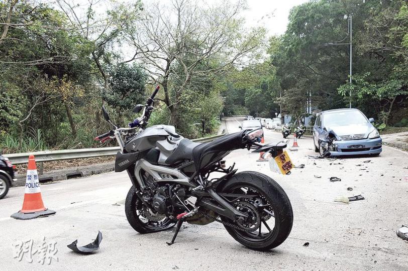 車禍後，肇事電單車損毁橫亘路中，及後由相關人員扶正等候拖走進一步檢驗。（賴俊傑攝）