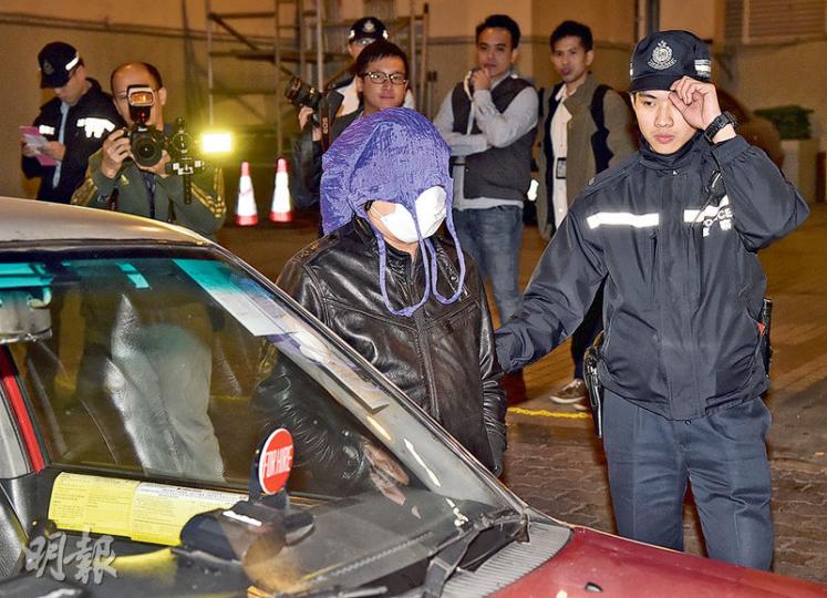 警方昨再在中區放蛇拘捕「黑的」司機。其中一名被捕司機被押走時自行戴上口罩及用紫色環保購物袋作頭套掩面,以避過傳媒鏡頭。(蔡方山攝) 警方昨再在中區放蛇拘捕「黑的」司機。其中一名被捕司機被押走時自行戴上口罩及用紫色環保購物袋作頭套掩面,以避過傳媒鏡頭。(蔡方山攝)