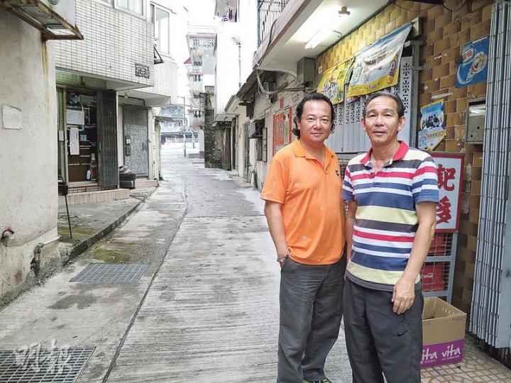 當區區議員鄧鎔耀（左）及河瀝背村長鄧英斌（右）都是原居民，見證圍村「國際化」，聚居不同種族的居民。「不少外籍人士在這裏落地生根，他們的小孩會向我利市呢！」鄧村長說。（黃熙麗攝）來自尼日利亞的Ben在錦田經營廢車場，將零件運往非洲各國，笑言十分喜歡香港的生活。（黃熙麗攝）Ben辦公室的牆上貼滿他參與社區活動的照片，還有警方頒給他當翻譯義工的感謝狀。（黃熙麗攝）