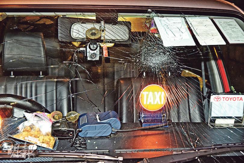 的士無辜遭兇徒擊毁擋風玻璃及車窗，後座遺下大灘血漬；司機無奈說，首次遇上這種事情，因的士被毁及需協助調查，致無法做生意。（蔡方山攝）