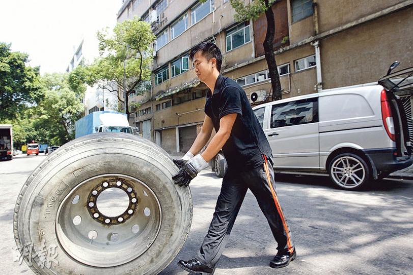 鍾浩賢烈日下推着大車胎，坦言有點吃力，但他盼為輪胎行業帶來新希望。（郭慶輝攝）