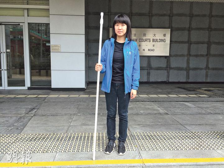 被告鄧美晶昨在庭外展示當日攜帶的伸縮膠棍，稱港鐵職員當時沒要求她縮短已伸長的膠棍，惟承認該膠棍最短仍達1.5米。（黃文雋攝）