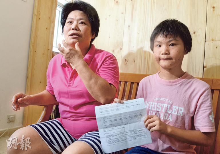 11歲的愛藍（右）患有罕有病「約伯綜合症」，除臉上及全身長腫瘡，細菌感染風險亦高於常人，因此常備醫生紙，一發燒便須立即入院盡快診治，母親羅女士（左）坦言多年來照顧愛藍心力交瘁，但慶幸愛女從小聽教懂事。（劉焌陶攝）