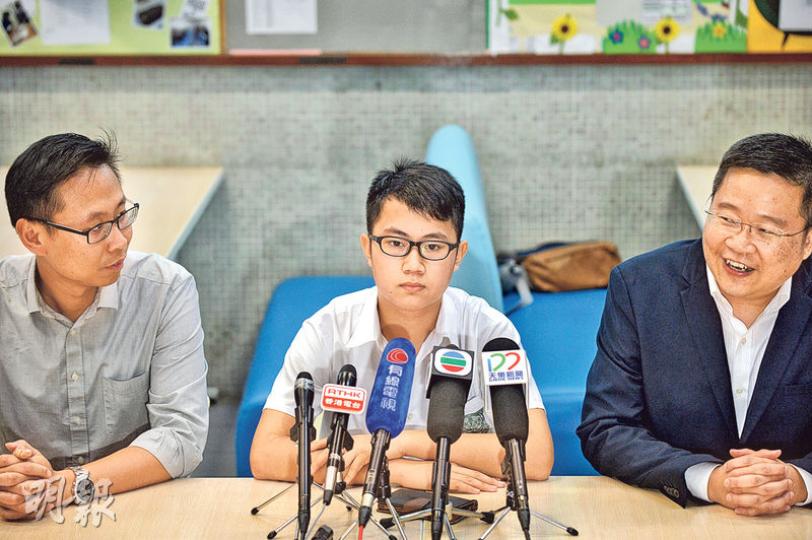 元朗信義中學本土關注組成員、中三學生梁彥樂（中）昨午在副校長譚建勳（右）及德育及公民教育科主任林官麟（左）陪同下見傳媒。梁多次強調與校方會面氣氛良好，又稱自願出面澄清，絕對沒有受壓。（ 蘇智鑫攝）本應昨早11時放學的梁彥樂，放學後被留下溝通，至下午4時許才在學校辦公室吃飯盒。（蘇智鑫攝）