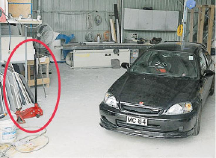 涉事車主疑以油壓車唧(紅圈示)托起座駕,爬入車底維修時,汽車突然墜地將他壓死。(衛永康攝) 涉事車主疑以油壓車唧(紅圈示)托起座駕,爬入車底維修時,汽車突然墜地將他壓死。(衛永康攝)