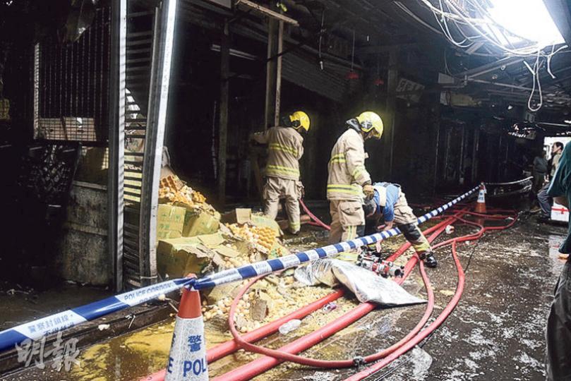 消防員昨晨重返果欄三級火現場位置調查起火原因，其中一間受波及的欄檔內多箱雞蛋散滿一地。（葉真真攝）前日險葬身火海的唐狗美美，昨晨隨同主人返回果欄「開工」，活潑依然。（賴俊傑攝）