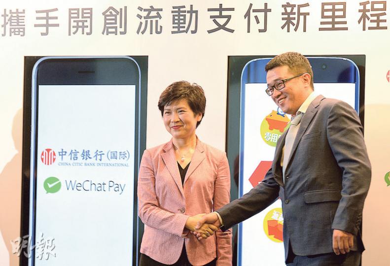 繼年初綁定信用卡戶口後，信銀國際再伙WeChat Pay香港錢包，首創存款戶口綁定電子錢包，提供實時小額轉帳、結餘購物等服務。圖左為信銀國際個人及商務銀行業務、策略業務執行總經理李慧燕，右為WeChat代表。（劉焌陶攝）