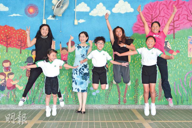 香港青年協會李兆基小學今學年減少測考，家長都指已感受到子女學習時較以前更快樂、主動，後排左二為校長謝煒珞。（蘇智鑫攝）