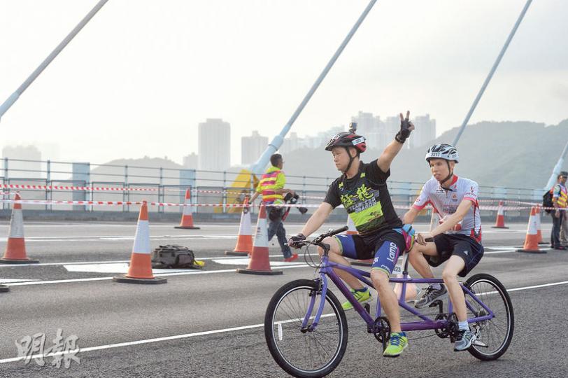50公里組項目，大會除邀得海外頂尖車手參與，亦有兩組由視障及聽障者組成的「猛龍」成員參與，其中一組聽障者蘇先生（前）與視障者鄭先生（後）利用雙人車參賽，前者負責維持單車平衡及方向，後座專心為單車提供動力。（蘇智鑫攝）單車節今年新增50公里組，路線由「三隧三橋」組成，車手會經過汀九橋（圖）、青馬大橋及尖山隧道等，有車手說由於難得可以踩單車在大橋及隧道奔馳，因此路程中不時有人自拍。（蘇智鑫攝）單車節亦有家庭單車樂活動，父母可與子女一同坐三輪車，來回海旁附近馬路。活動在早上近10時開始，當時氣溫約30